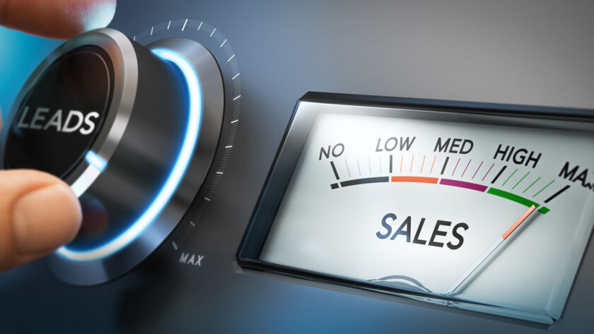 Close-up of a hand adjusting a futuristic dial labeled LEADS beside a gauge reading toward high on a SALES meter, indicating rising sales performance. Cogo Interactive offers expert digital marketing and web design services in Northern Virginia, Maryland, and Washington, DC.